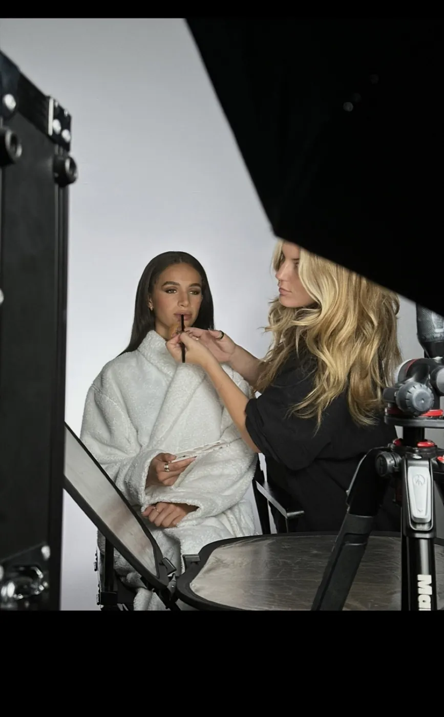 Zoë Elizabeth applying lip colour to a model on set