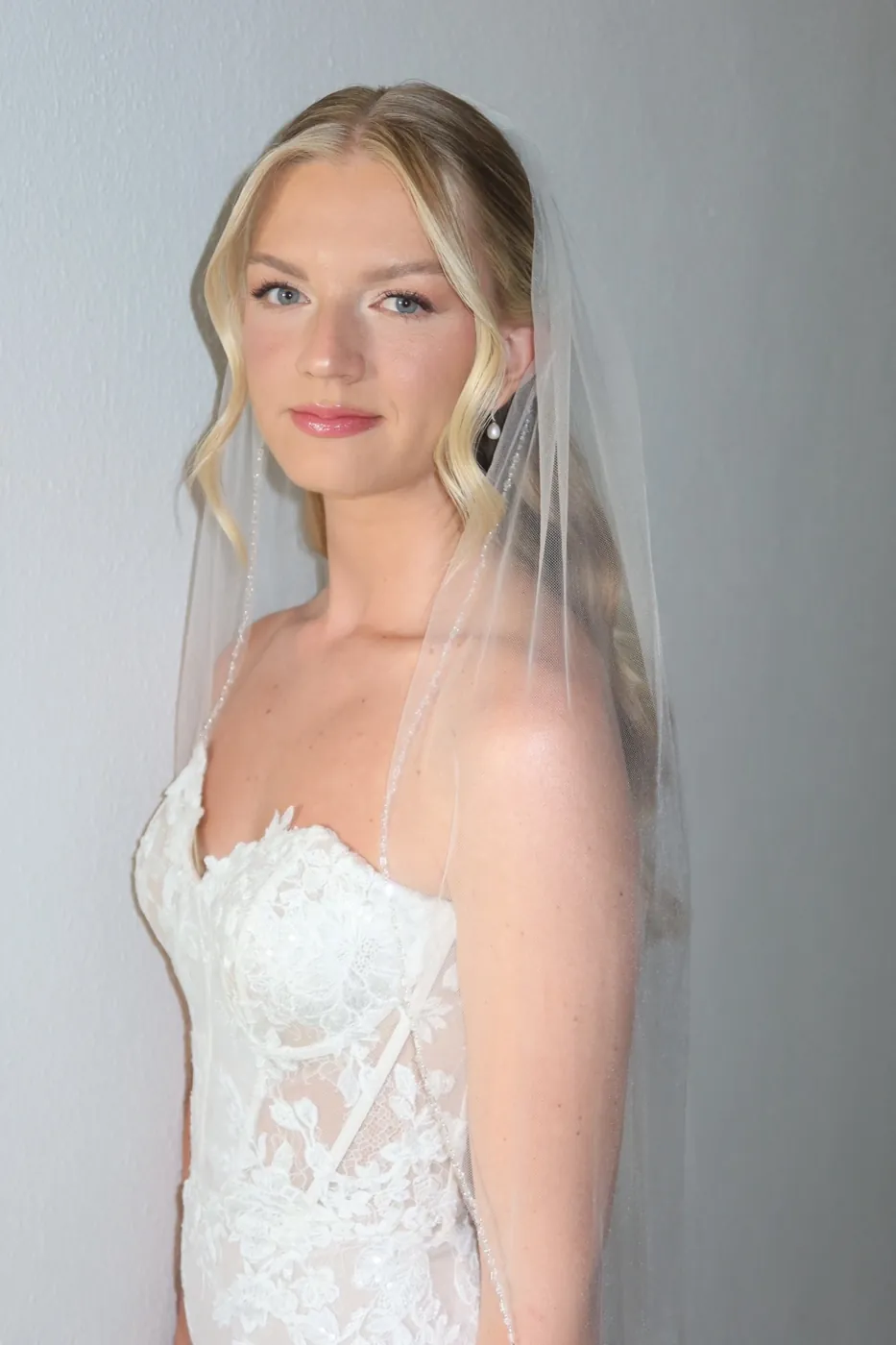 Blonde bride in a sheer veil with soft, luminous skin