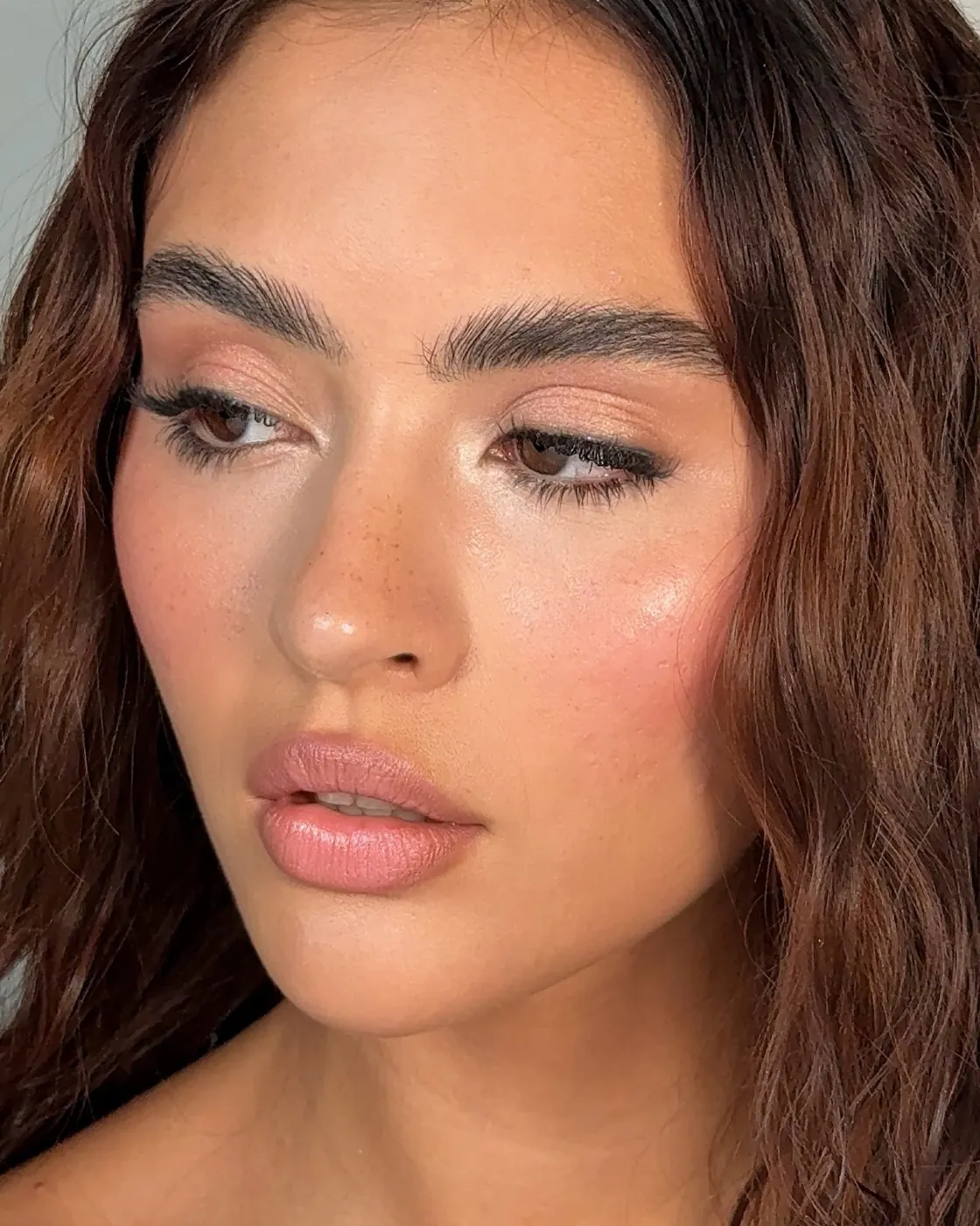Freckled skin with a soft brown eye and flushed cheeks