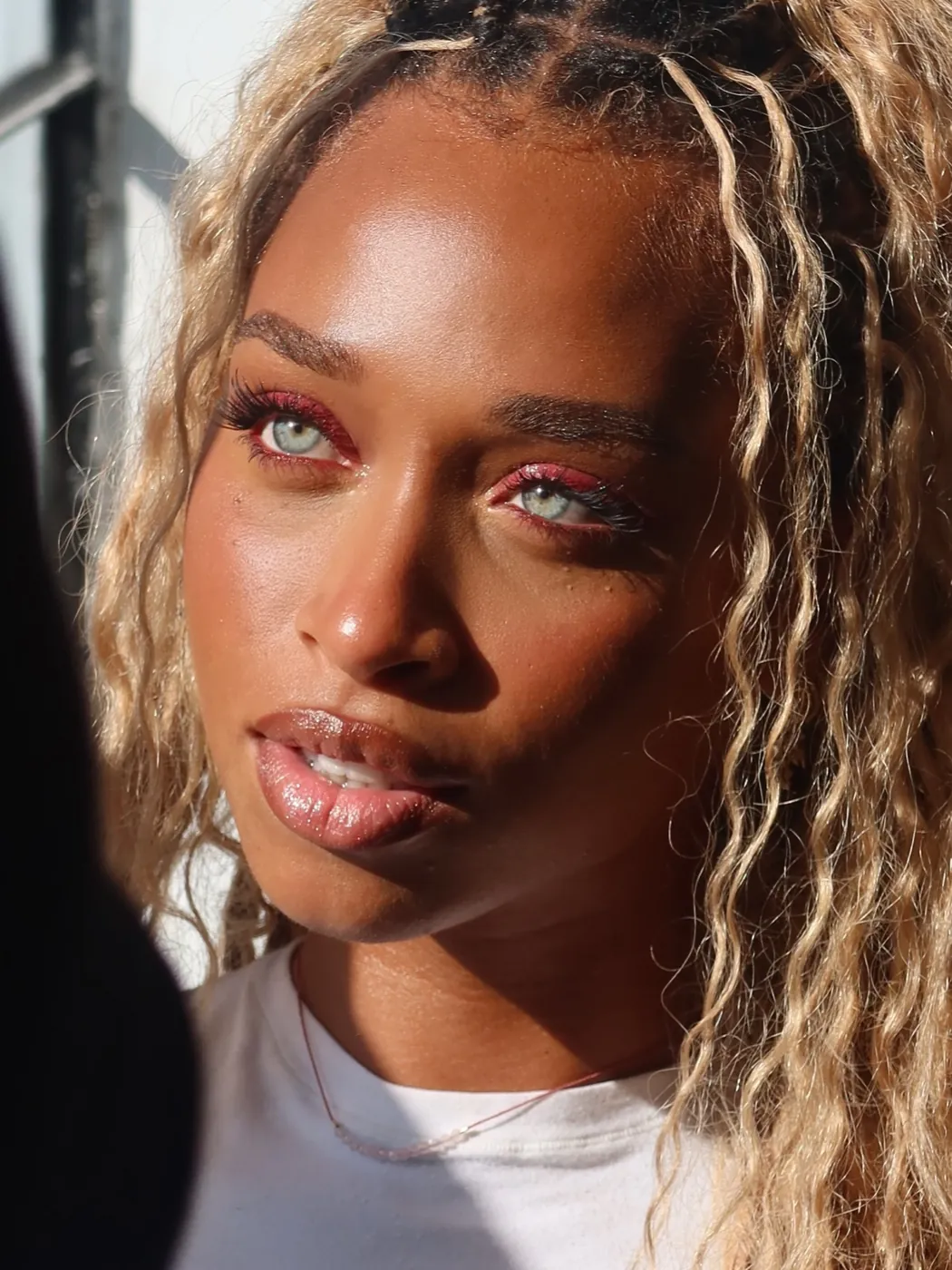 Dewy, glowing skin with blonde braids in golden light