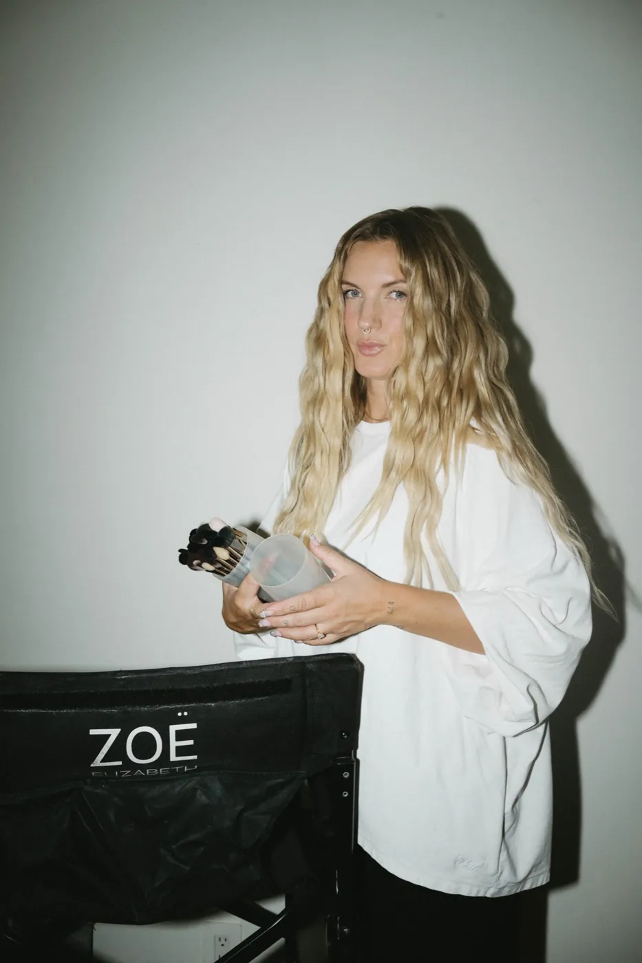 Zoë Elizabeth in her director&rsquo;s chair holding a brush